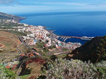 High angle view of townscape by sea against sky