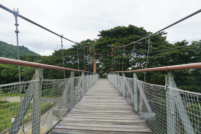 Rear view of man walking on footbridge