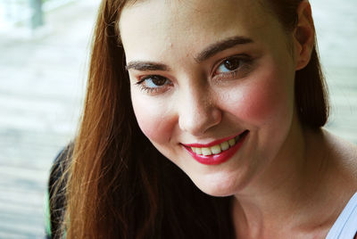 Close-up portrait of smiling young woman wearing pink lipstick