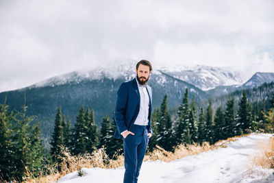 Young man standing on snowcapped mountain