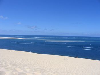 Scenic view of beach against blue sky