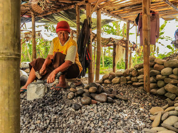 Portrait of senior man standing by logs