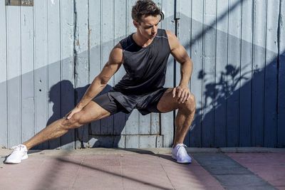 Full length of young man exercising in gym