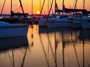 Boats in sea against sky during sunset