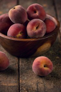 Peach fruits in bowl on table