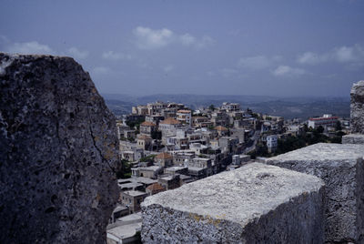 Buildings in city against cloudy sky