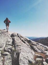 Rear view of a woman walking on rocky landscape