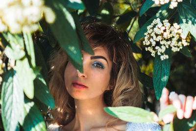 Close-up portrait of woman  in flower bush