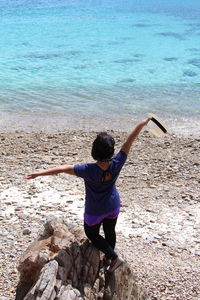 Full length of young woman standing on beach