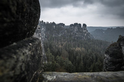 View of rocks on land against cloudy sky