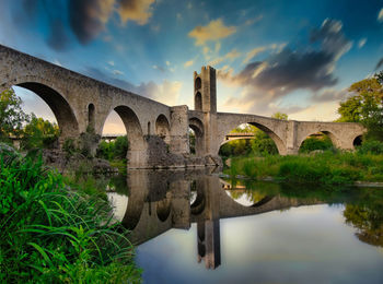 Medieval village besalú in catalonia spain, beautiful sunset sky and water reflection