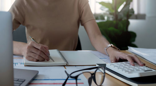 Midsection of man using laptop on table