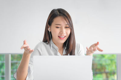 Young woman using laptop while sitting on table