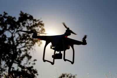Low angle view of woman jumping against sky