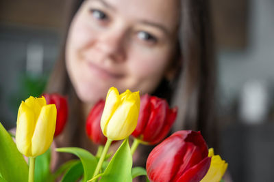 Close-up of young woman with red flower