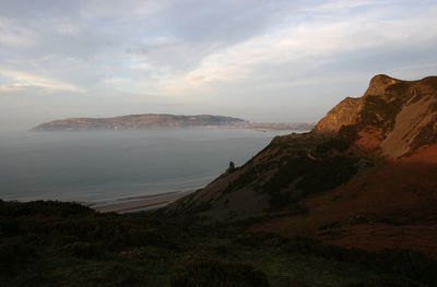 Scenic view of sea and mountains against sky