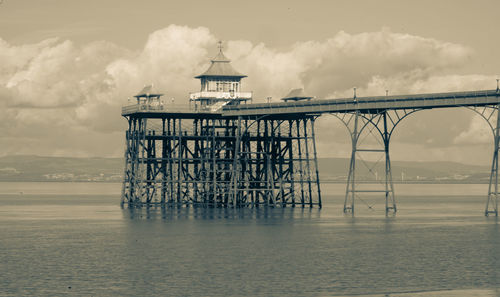 Built structure on pier over sea against sky