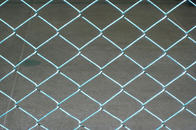 Full frame shot of chainlink fence against wall