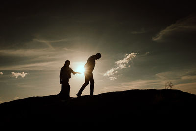 Low angle view of silhouette man standing against sky during sunset