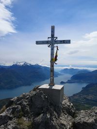 Cross on rock against sky