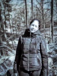 Portrait of young woman standing on snow covered land