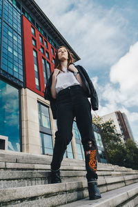 Low angle view of woman standing against sky