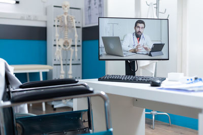 Rear view of woman using laptop at clinic