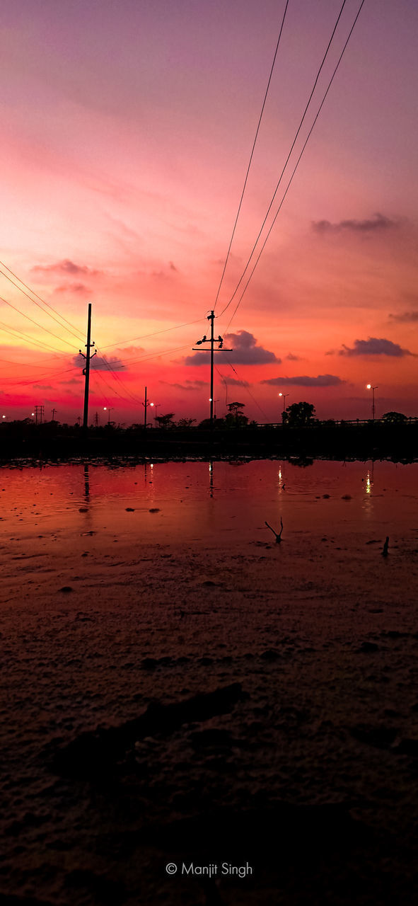 SILHOUETTE ELECTRICITY PYLONS AGAINST ORANGE SKY