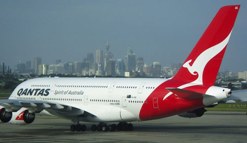 View of airplane in city against sky