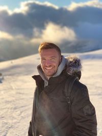 Portrait of smiling man standing in snow