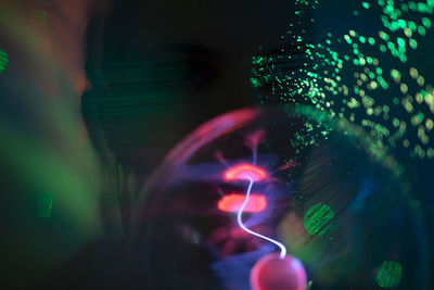 Blurred motion of woman seen through car windshield at night