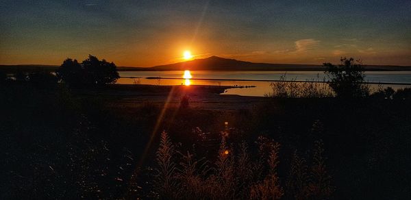 Scenic view of lake against sky during sunset