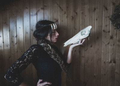 Rear view of woman standing on wooden wall