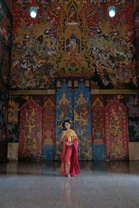 Full length of woman standing against building