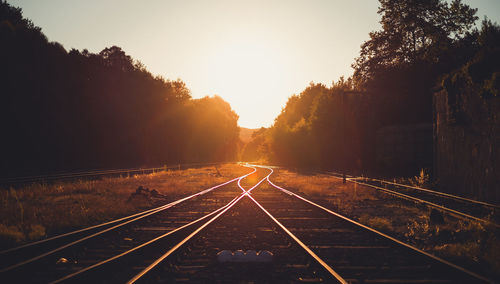 Railroad tracks against sky on sunny day