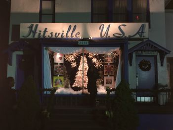 Illuminated lanterns hanging by building at night