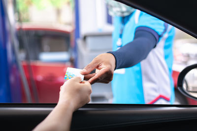 Cropped hand of man washing car