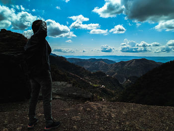 Man standing on mountain against sky