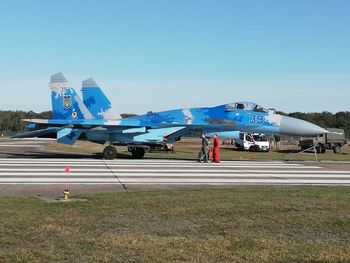 Airplane on airport runway against clear blue sky