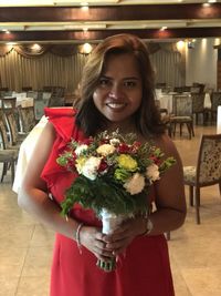 Portrait of smiling young woman holding bouquet