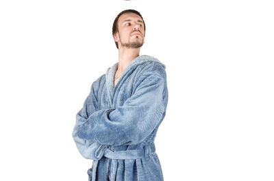 Young man looking away against white background