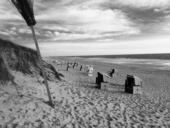 Scenic view of beach against cloudy sky