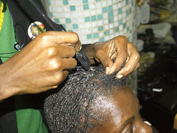 Cropped image of man braiding woman hair