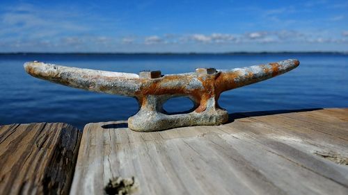 Close-up of rusty bollard on pier by sea