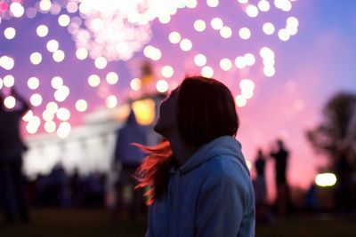 Rear view of woman standing against blurred background