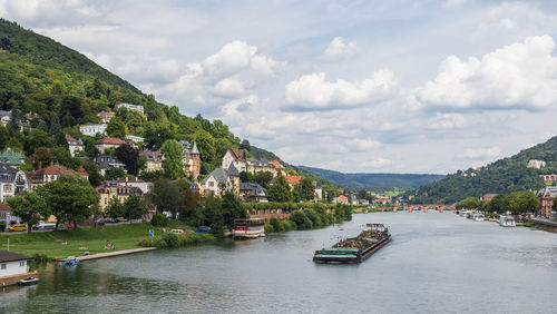 Scenic view of river by buildings against sky