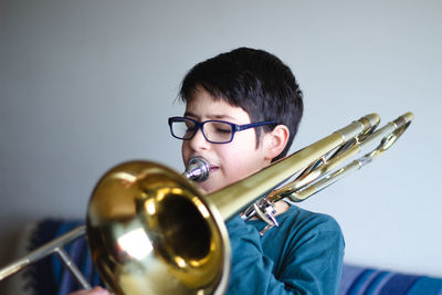 Boy playing trombone at home