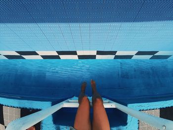 Low section of woman legs in swimming pool