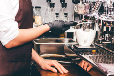 Midsection of man having coffee at cafe