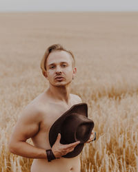 Portrait of young man standing on field